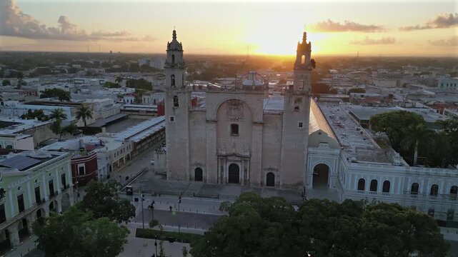 Aerial view of the colonial-era cathedral bathed in the warm glow of sunset in Plaza Grande, displaying the architectural beauty, Merida, Mexico.