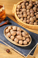 Dried Longan Fruit in Bamboo Baskets with Tea - Traditional Asian Snack and Cooking Ingredients