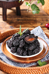 Dried Prunes in Bowl on Wooden Tray with Herbs - Healthy Organic Snack Food Photography