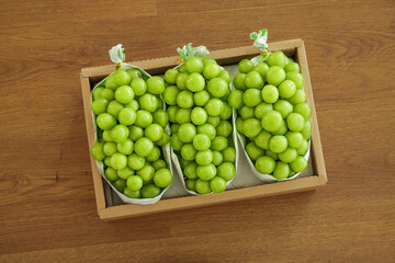 Fresh Green Grapes in Paper Bags Wooden Box on Wood Table