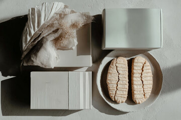 Minimalist still life with decorative boxes, fabric, and cookies on a plate