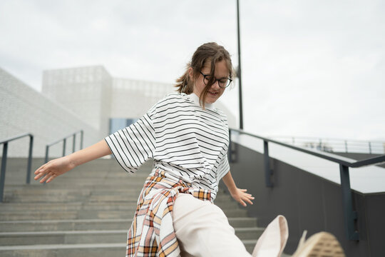 Energetic young girl dancing joyfully in urban setting