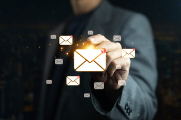 Businessman hand touching glowing email icons with notification, digital communication concept for...