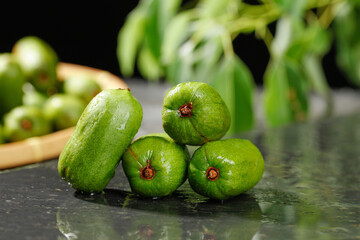 Fresh Green Feijoa Fruits on Dark Marble Counter with Soft Natural Lighting