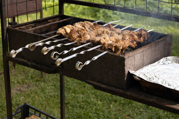 Juicy slices of meat prepare on the fire. Tasty shish kebab on skewers. Grilled marinated barbecue meat - shashlik on pork
