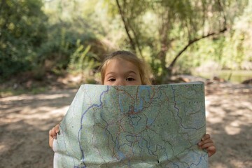 Curious girl exploring with map in nature