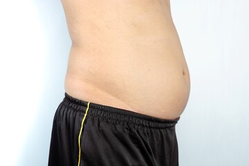 Naklejka premium male showing of an overweight belly