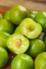 Fresh Green Plums Cut in Half Showing Yellow Pulp and Pit - Healthy Stone Fruit