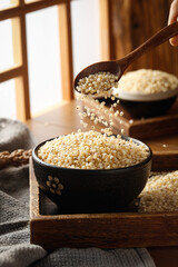 Fresh Quinoa Grains Pouring from Wooden Spoon into Bowl - Organic Superfood Kitchen Scene