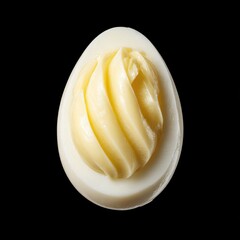 Unique presentation of butter shaped like a boiled egg set against a black background