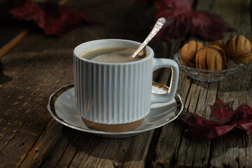 Fall season. Espresso coffee on rustic wooden table, surrounded by colorful autumn foliage