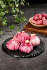 Fresh Red Garlic Cloves from Shandong Farmers Market with Radishes on Slate Plate