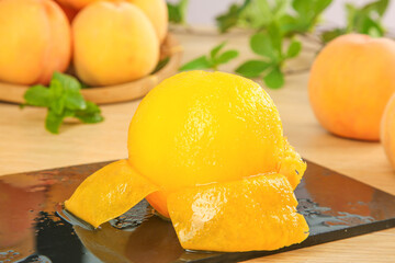 Fresh Golden Yellow Peach Slices on Cutting Board with Whole Peaches and Mint