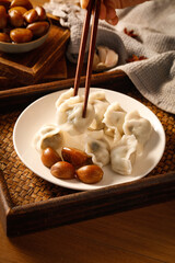 Asian Dumplings with Pickled Garlic and Chopsticks on Wooden Tray - Traditional Asian Cuisine
