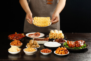 Chef Presenting Gourmet Appetizer Platter with Artisanal Cheese Rolls and Charcuterie Selection