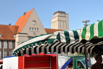Wochenmarkt in Delmenhorst auf dem Rathausplatz: Buntes Treiben mit Marktstände vor dem Rathaus und dem Wasserturm.