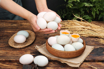 Fresh Large Duck Eggs with Deep Golden Yolks in Rustic Wicker Baskets on Wooden Table