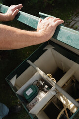 Man checking modern septic tank system outdoors.