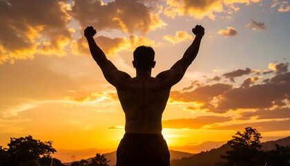 Fototapeta premium Silhouette of a muscular man celebrating a sunset victory