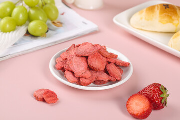 Dried strawberry slices healthy snack with fresh fruit and pastries on pink background