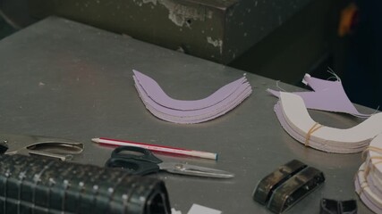 close up of leather pieces and tools in shoemaking workshop