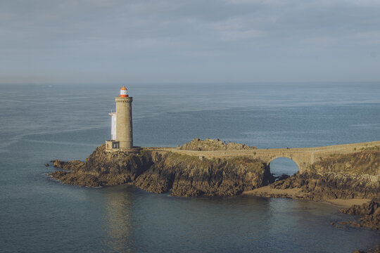View of the Petit Minou lighthouse with a red-topped beacon stands steadfast against the crashing waves, linked by a stone bridge, Plouzan&Atilde;&copy;, France.