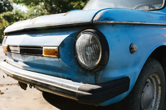 Fototapeta Close-up of old blue vintage car front with rust and spider webs