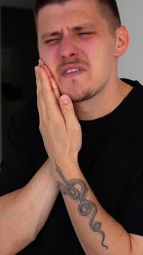 A man holds his cheek with his hand, showing severe toothache.
A man hides because of severe toothache.
Problems with caries and treatment of periodontosis