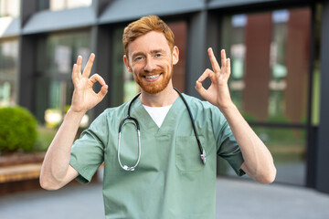 Smiling man in scrubs outdoors making ok gesture