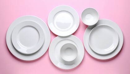 A set of clean white ceramic plates and bowls of different sizes arranged on a vibrant pink background. Concept of cleanliness and cooking