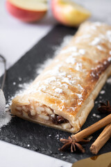 Homemade apple strudel on white marble background
