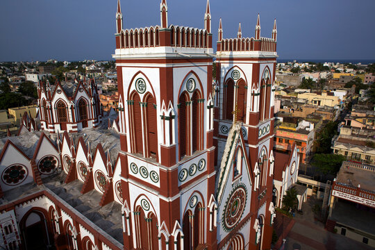 Aerial view of the striking red and white patterned spires of the San Thome Basilica rise high above the city streets, Chennai, Tamil Nadu, India.