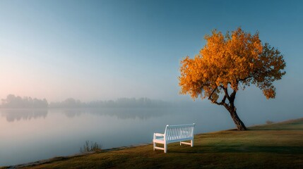 White bench inviting to contemplate autumn tree by misty lake at dawn