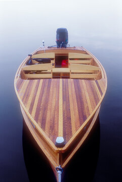 Antique wood boat floating on calm Saranac Lake