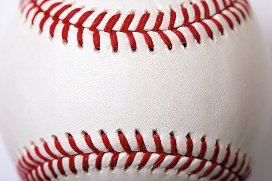 Close-up of white baseball stitched with red thread