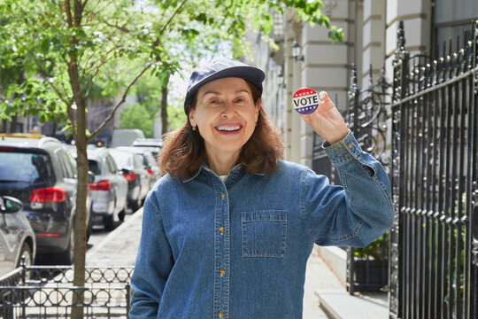 Portrait of smiling woman holding Vote badge