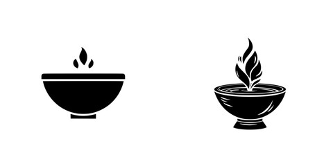 Set of two black silhouette icons of traditional oil lamps or diyas with flames, minimalist and ornate designs for spiritual or cultural concepts