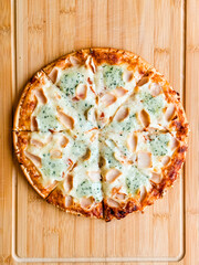 Sliced pizza with visible pieces and toppings on wooden board. Sharing, leisure and culinary...