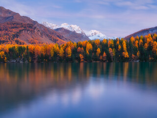 Nature. Mountain lake at dawn. Bright sky and clouds. Reflections on the water surface. Incredible view of the mountain valley. Photo for background, wallpaper, postcards.