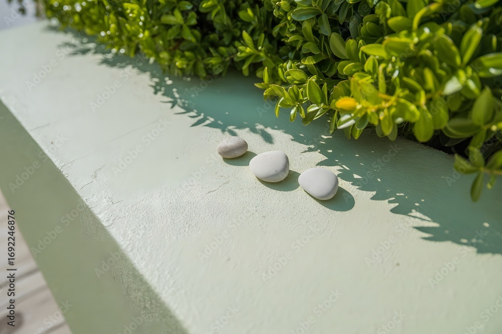 Aufkleber three smooth grey pebbles resting on a light green textured ledge casting subtle shadows with vibran