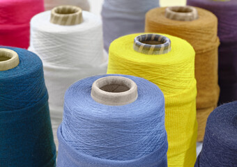 Group of large spools of thread of various colors