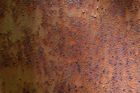 Close-up view of pitted, rusty metal wall