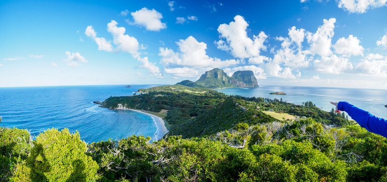 Hand of hiker pointing at Mount Gower and Mount Lidgbird on Lord Howe Island