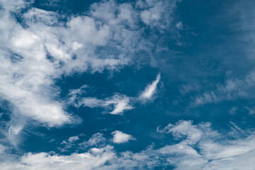 Vibrant blue sky with swirling white clouds and a calming atmosphere.