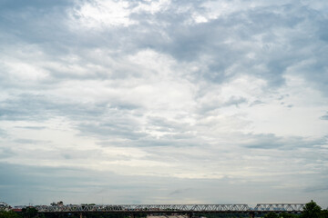 A tranquil view of a cloudy sky over a bridge reflecting calmness.
