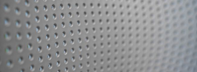 Close-up of a textured metallic surface with small perforations.