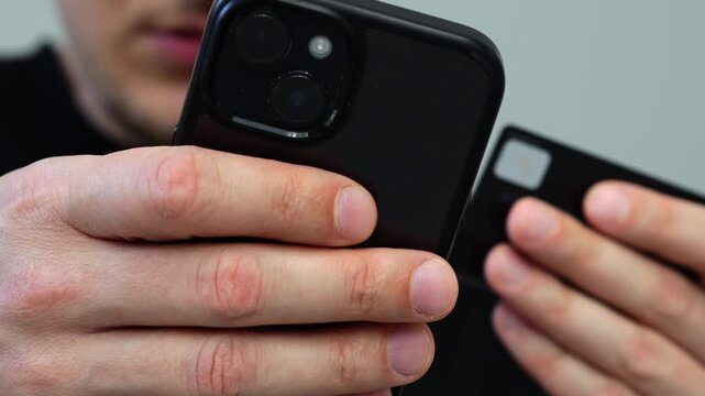 Online order and payment for goods using a credit card with money.
Money savings on a bank card of a man.
A guy with a mobile phone enters pinko d from a card