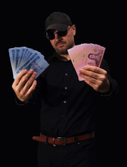 Stacks of currency displayed on bright red surface showcasing various banknotes