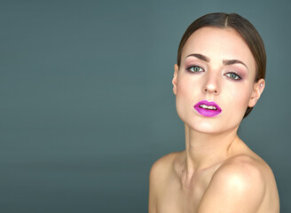 A woman with red lips and green eyes is depicted on a blue background, dressed in translucent...