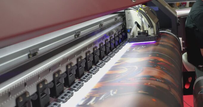 Large format printer printing a colorful image on white vinyl
